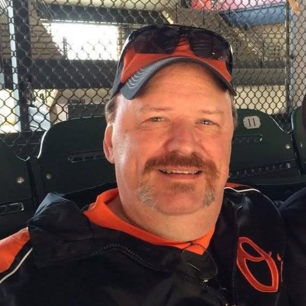 Wild Bill Ihrie, smiling, in an Orioles cap
