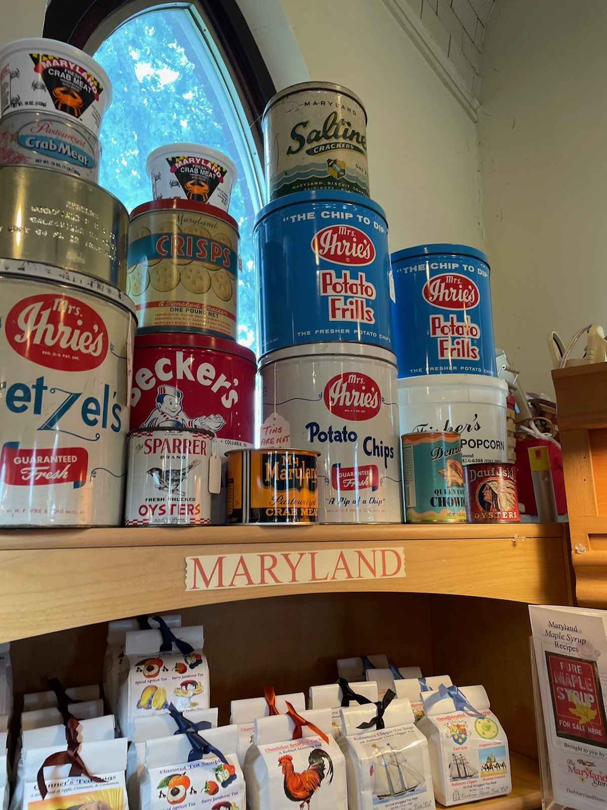 Vintage Mrs. Ihrie's Potato Chips tins stacked on a shelf in a Maryland shop