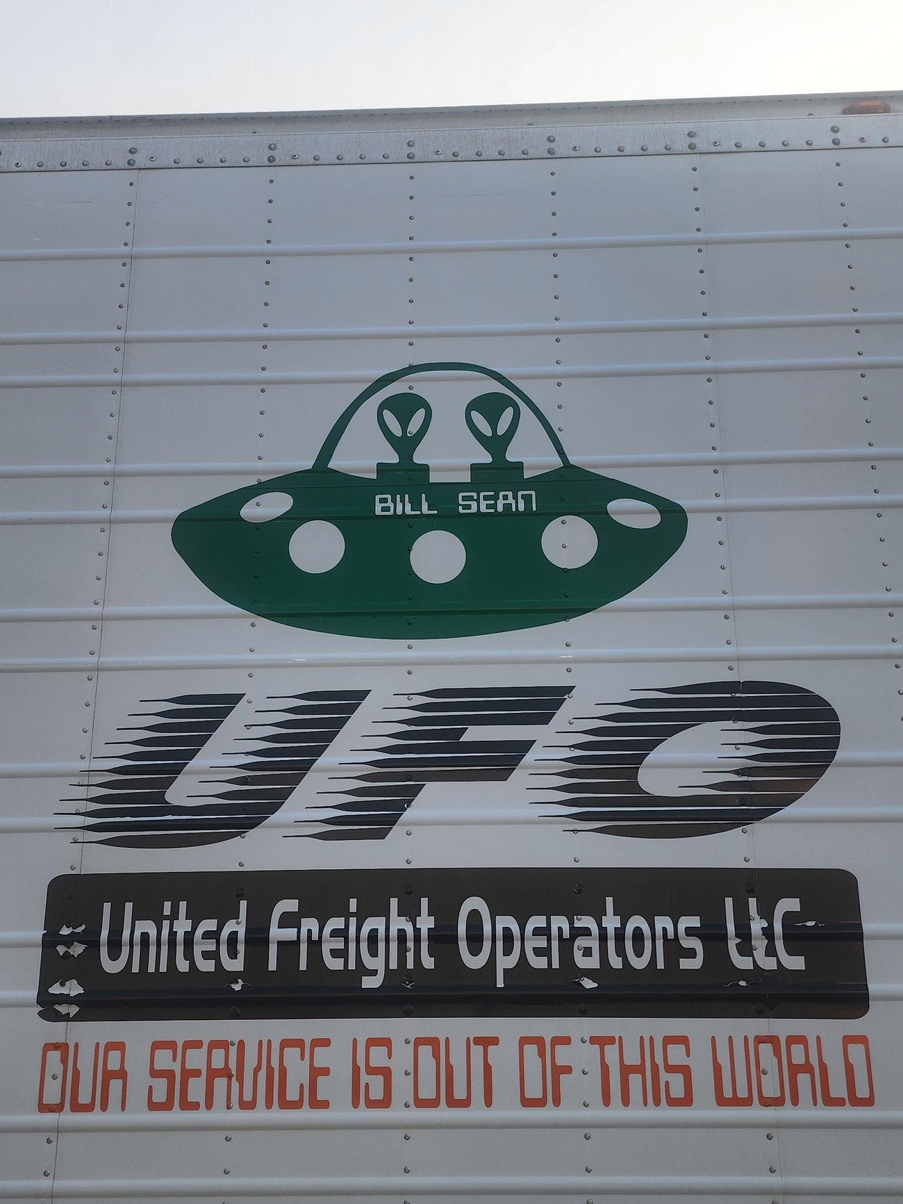 The UFO logo on the side of the trailer of Bill: a green flying saucer above the words United Freight Operators LLC and the line our service is out of this world