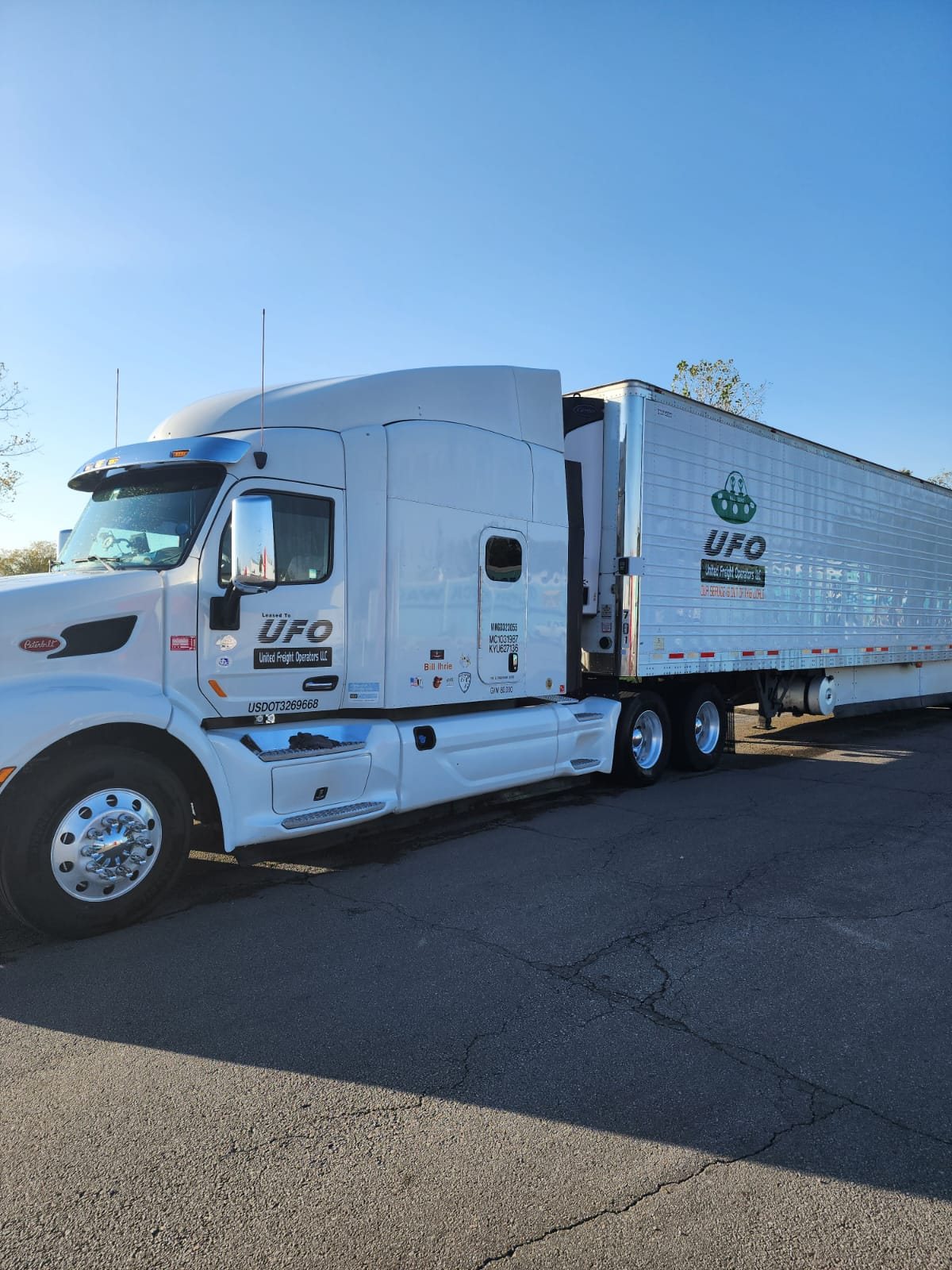 the white UFO tractor of Bill and reefer trailer in golden evening light